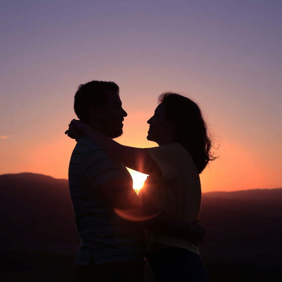 Paar dass sich umarmt bei Sonnenuntergang am Berg